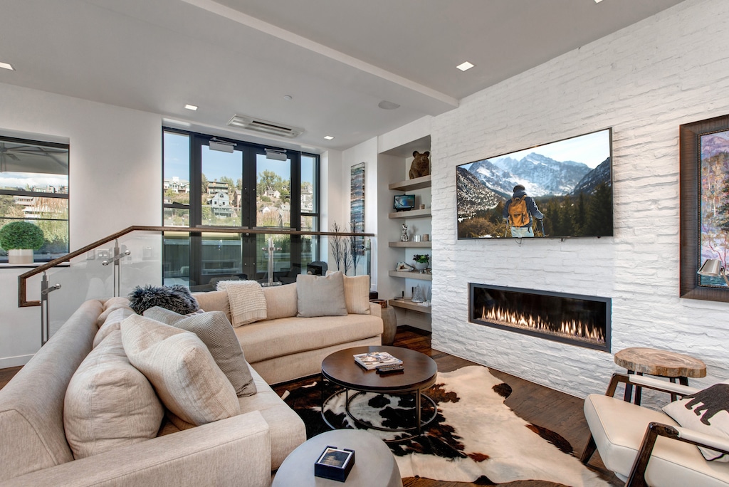 Living Room with a Comfortable Sectional Sofa, Gas Fireplace, 65" Smart TV with Cable Programming, and Patio Access