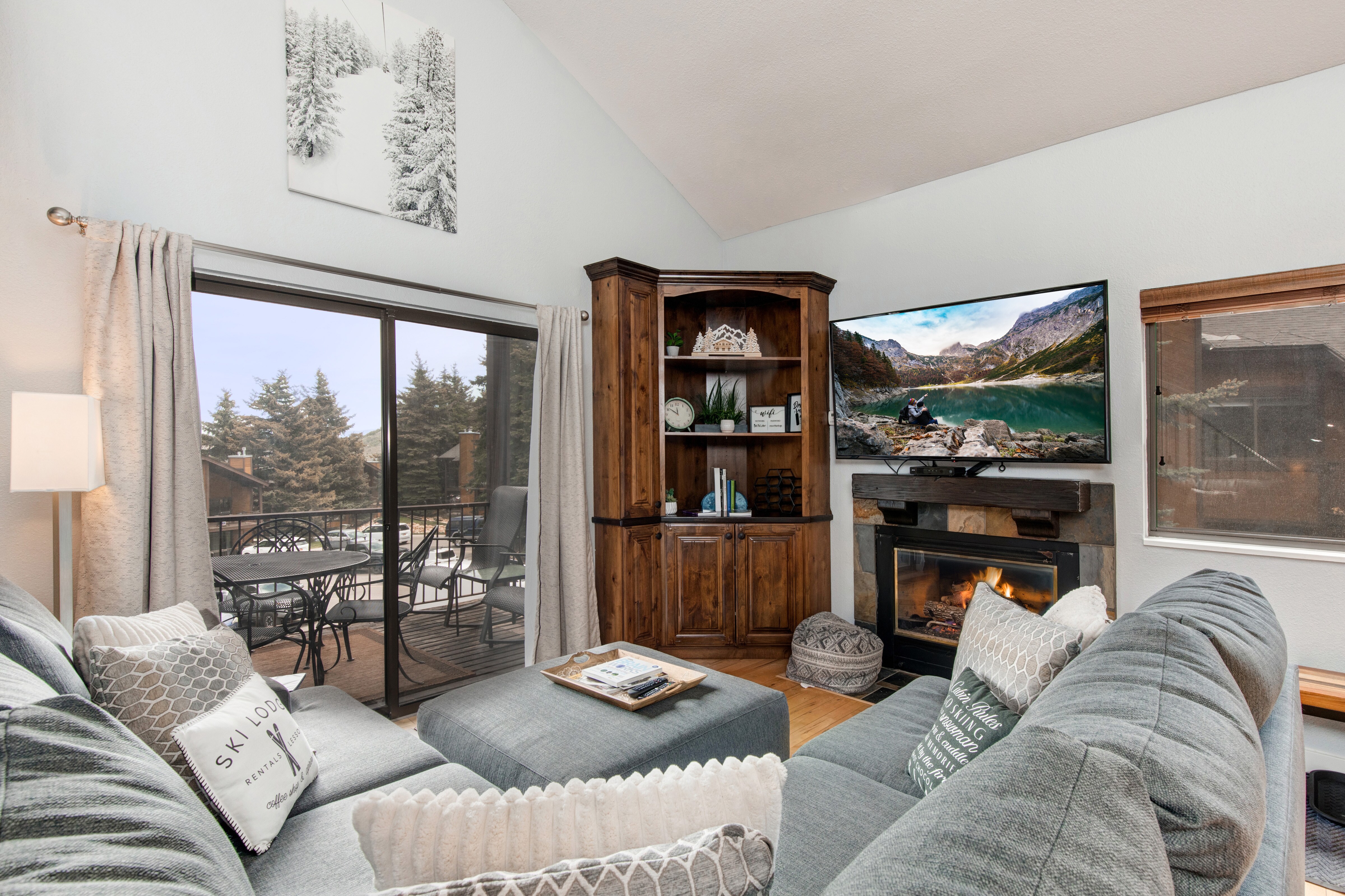 Living room with gas fireplace, Smart tv & sound-bar, plush furnishings, and private deck access