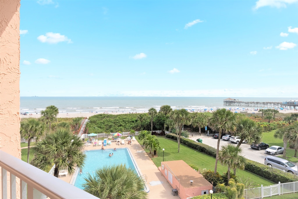 Scenic balcony view overlooking the pool and lush tropical surroundings.