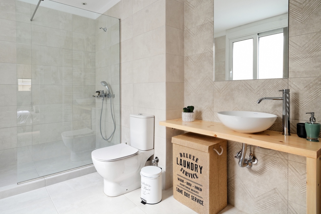 Bathroom with a spacious cabin shower, shower gel, shampoo and conditioner, a hair dryer and a hair straightener are provided.