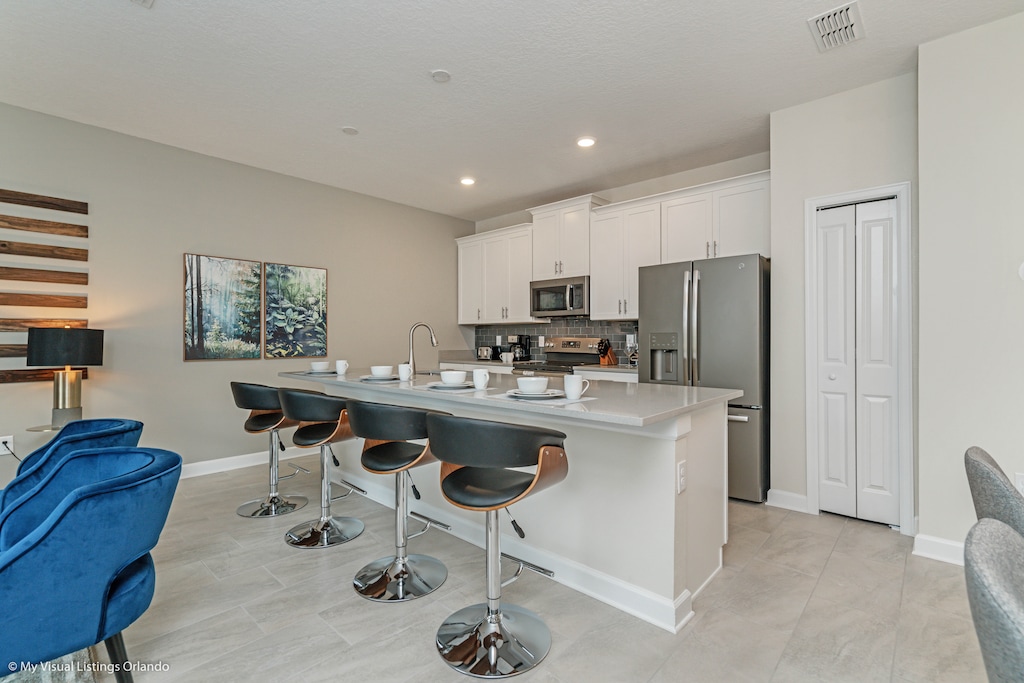 Modern Kitchen of the Townhouse in Kissimmee Florida - Sleek stainless steel appliances - High Chairs and Breakfast Bar - Smart use of space with versatile storage solutions