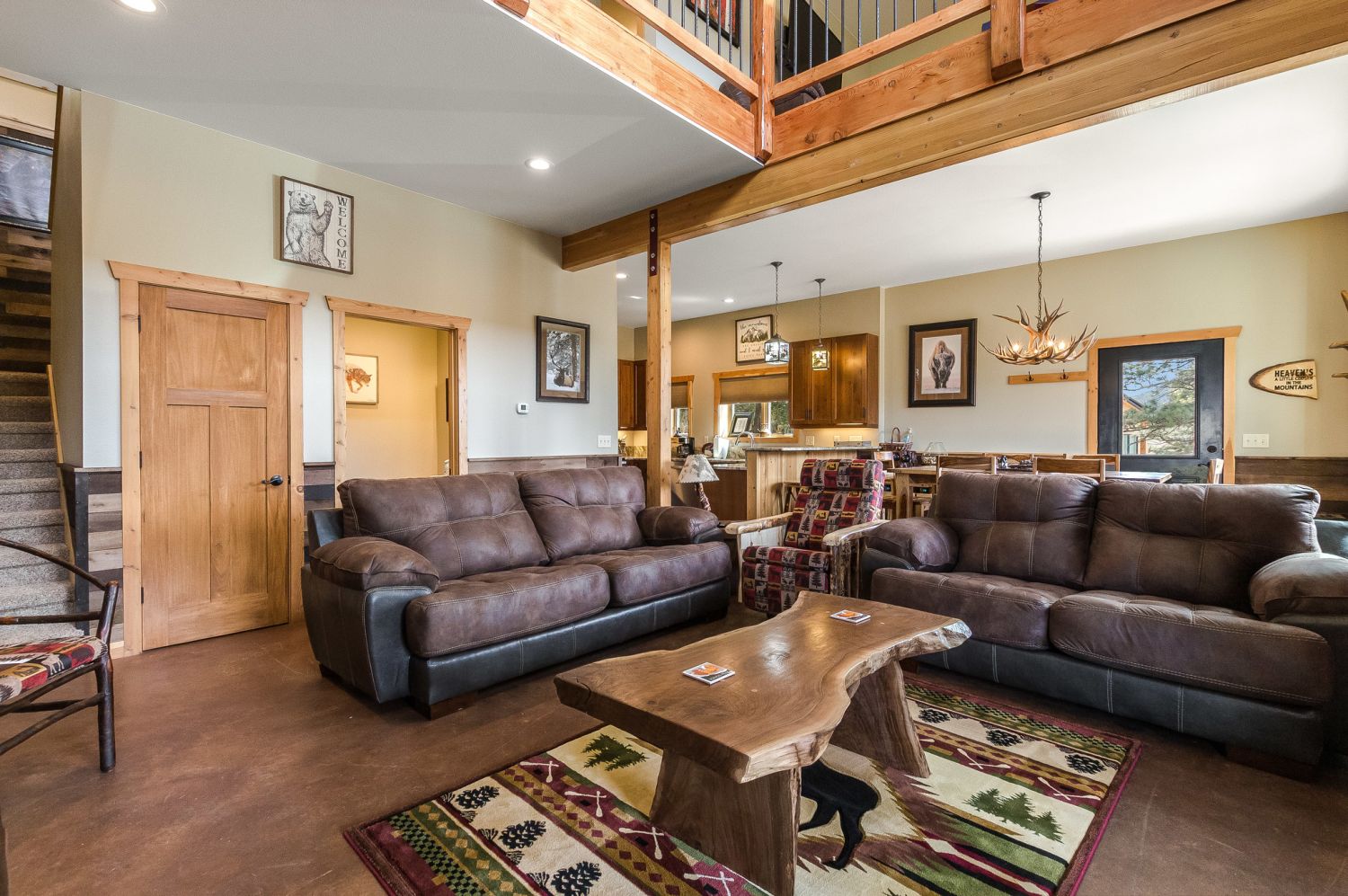Show Me Mountain Views - The living area features a large flatscreen TV, a fireplace, rustic wooden accent furniture, and comfy couches