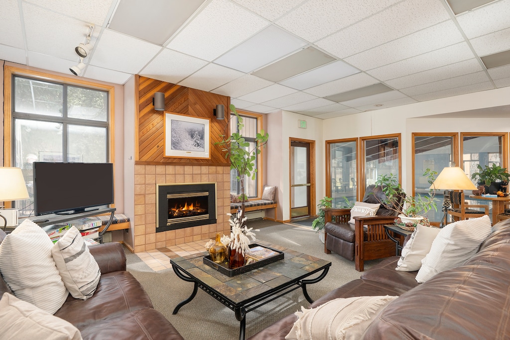 Cozy up at the clubhouse living room with warm fireplace, comfortable leather seating, and mountain views through large windows.