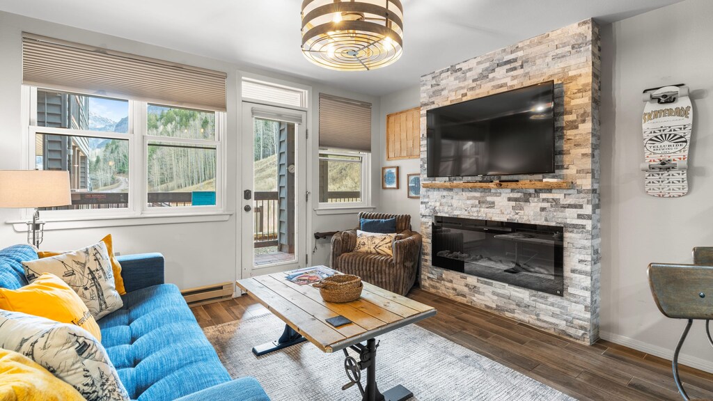 Cozy living room with mountain views and a stone fireplace.