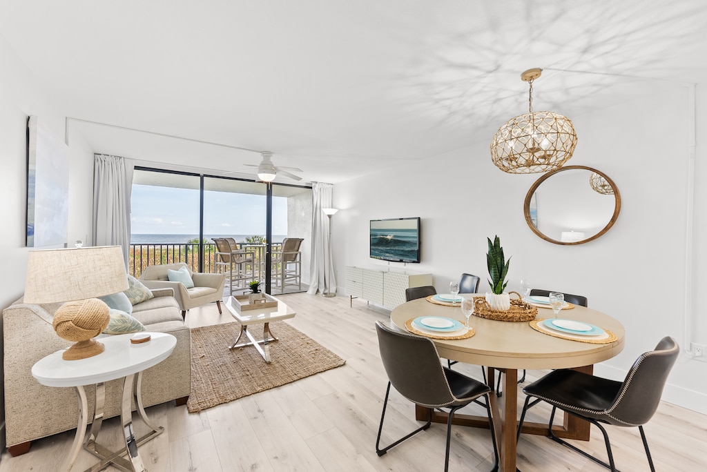 Elegant open-concept dining and living area with ocean views, stylish decor, and natural light.