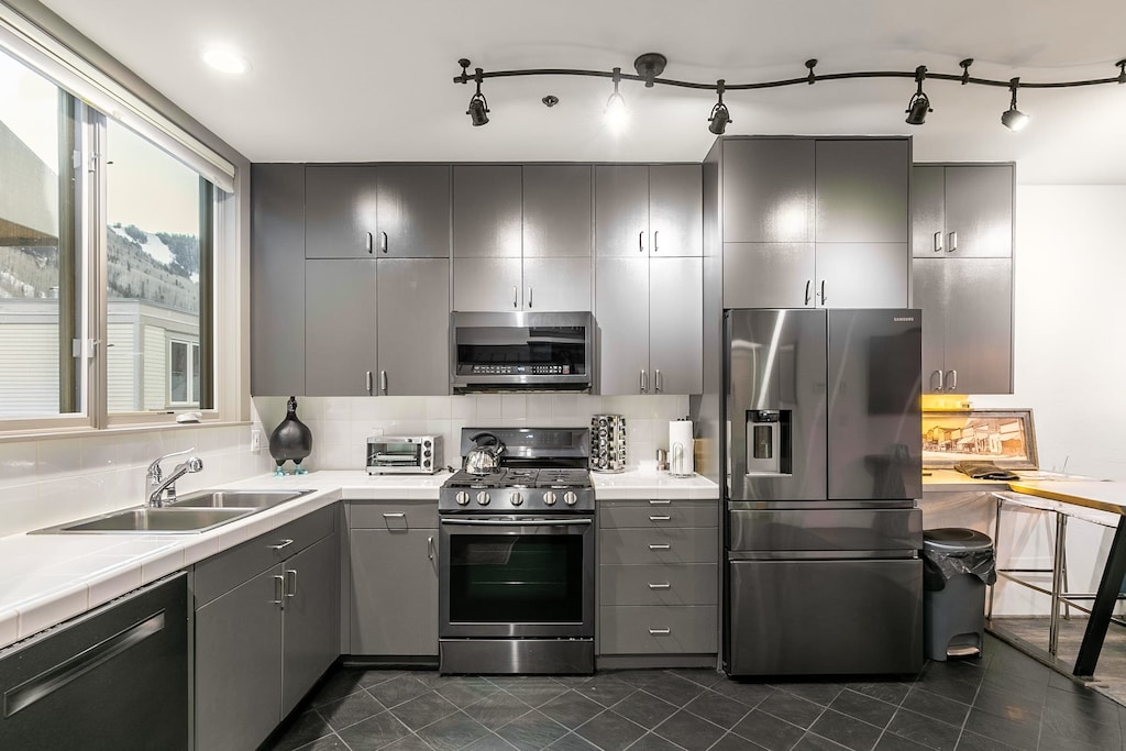 Modern kitchen with track lighting, tons of prep space, and a gas stove.