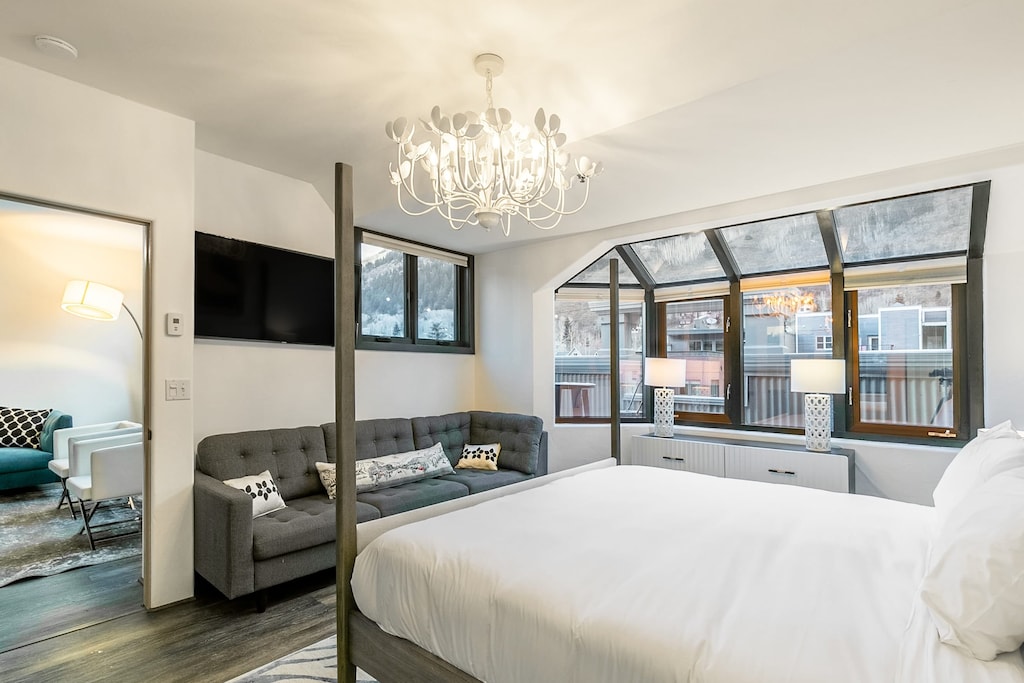 Primary bedroom features a king bed, ensuite bathroom, sofa, and TV.