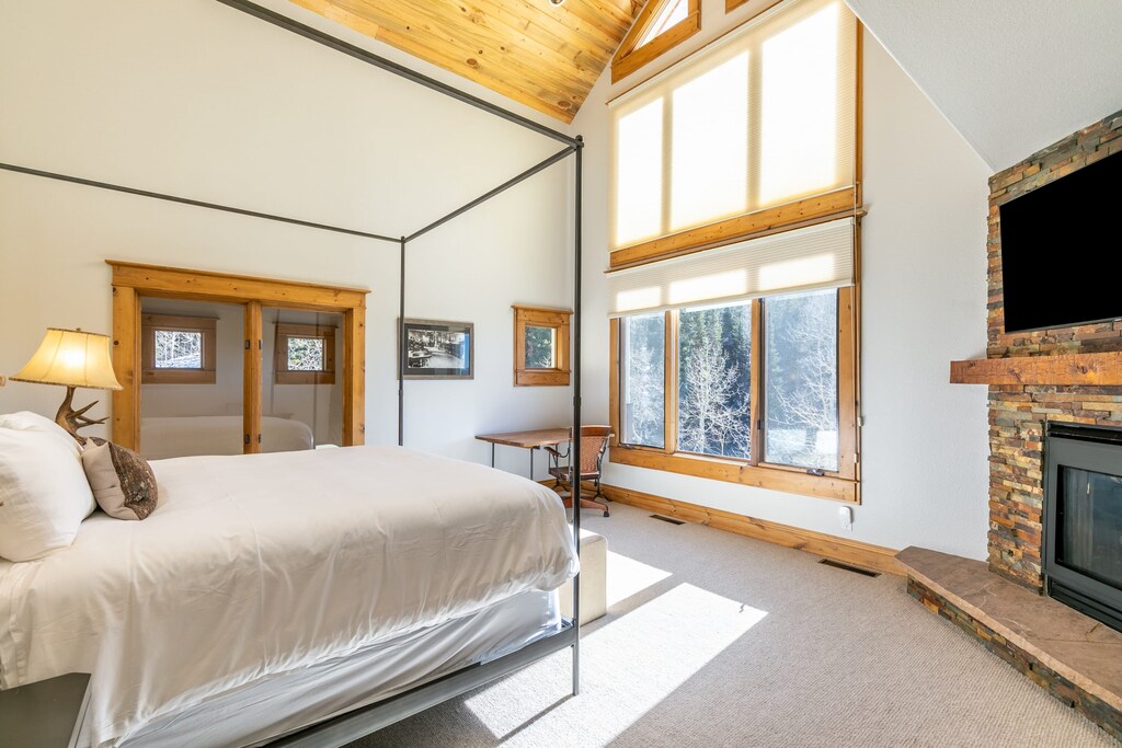 Primary bedroom features a king bed, desk, TV, Fireplace and an ensuite bathroom.