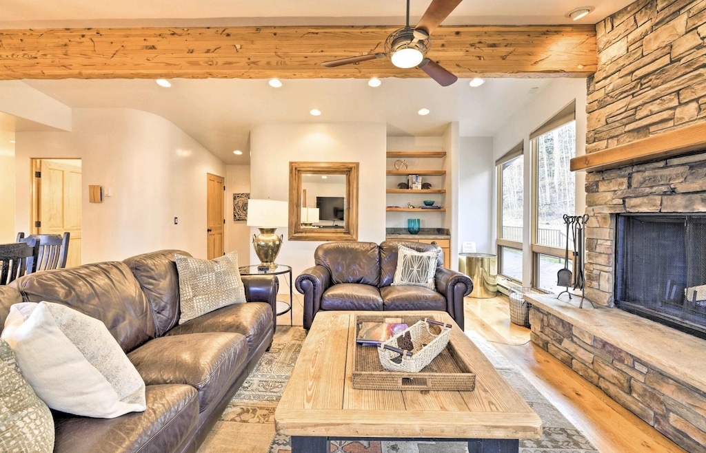 Living room with ceiling fan and fireplace