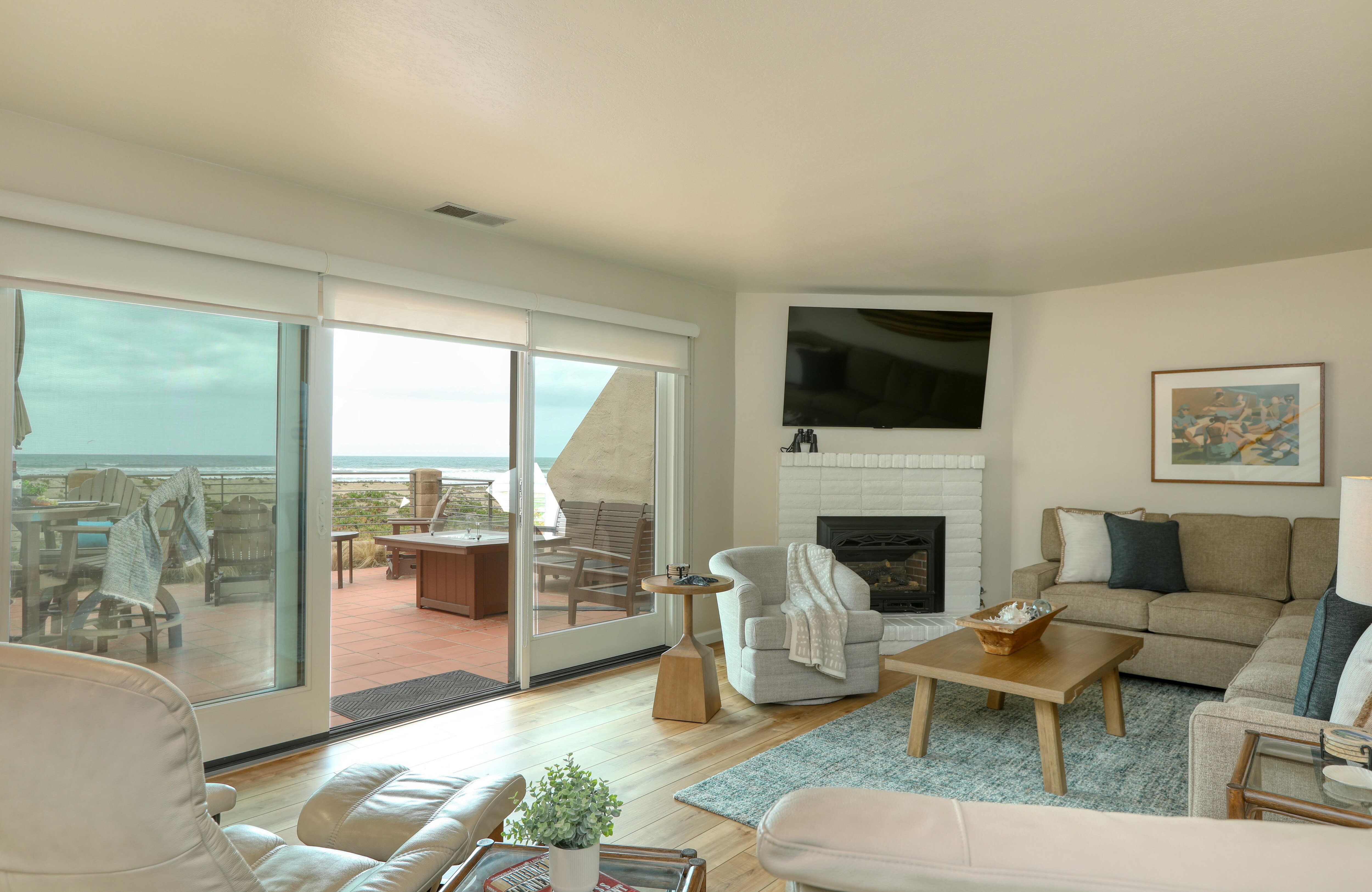 The living room is nestled at sea level, just down a flight of stairs. It features a cozy natural gas fireplace, a SmartTV for all your entertainment needs, and a sectional sofa with a queen pullout for extra guests.