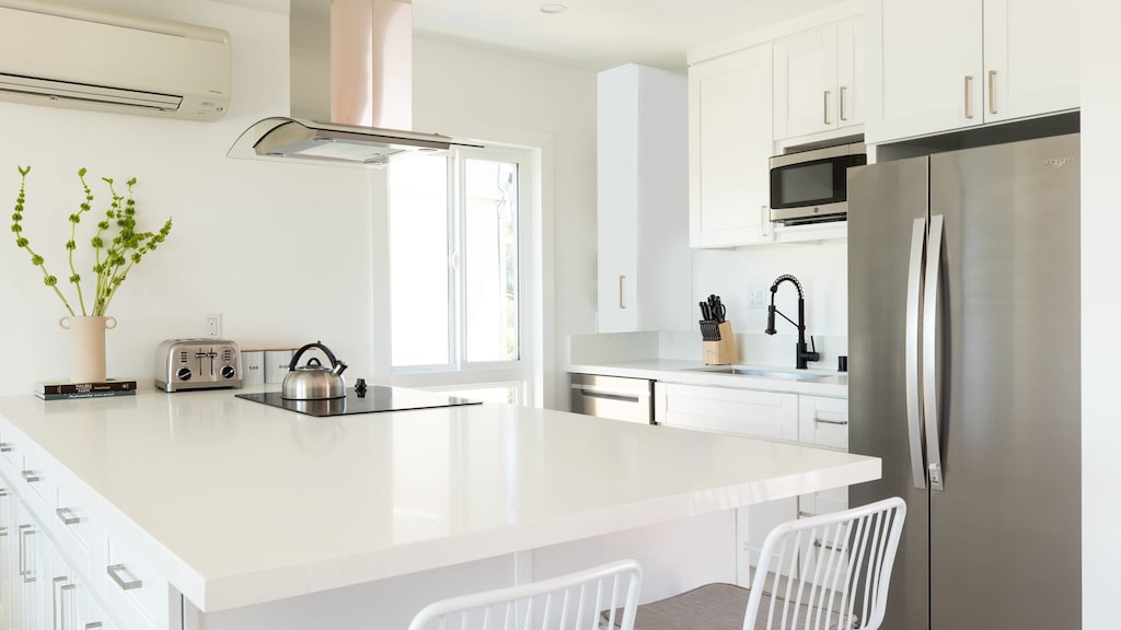Kitchen features modern appliances and a breakfast bar.
