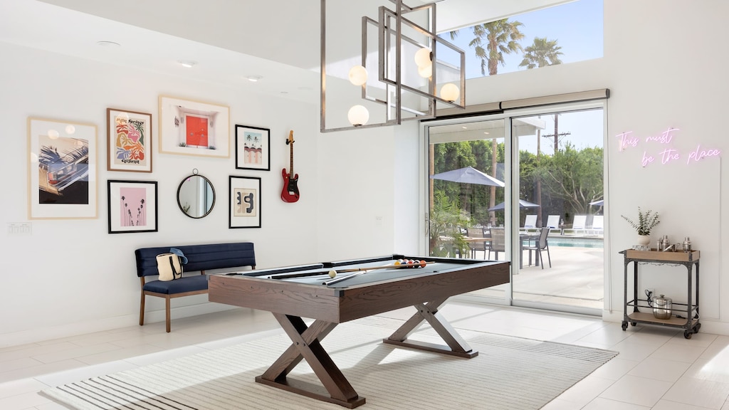Bright game room leads outdoors and features a pool table.