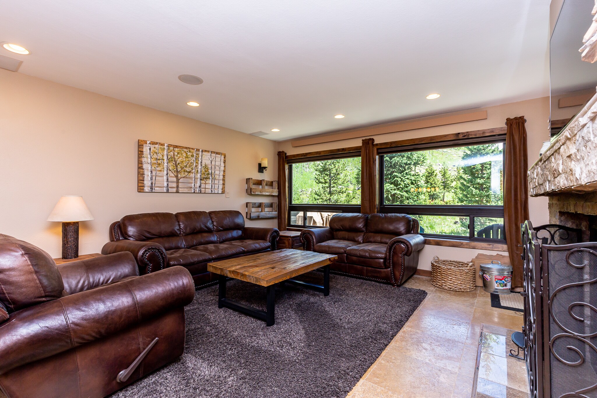 The living area features a wood-burning fireplace, a mounted flat-screen TV, and ample seating.