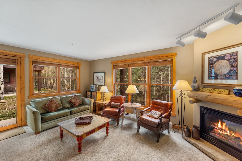 Living area with flat screen TV, fireplace and access to private patio