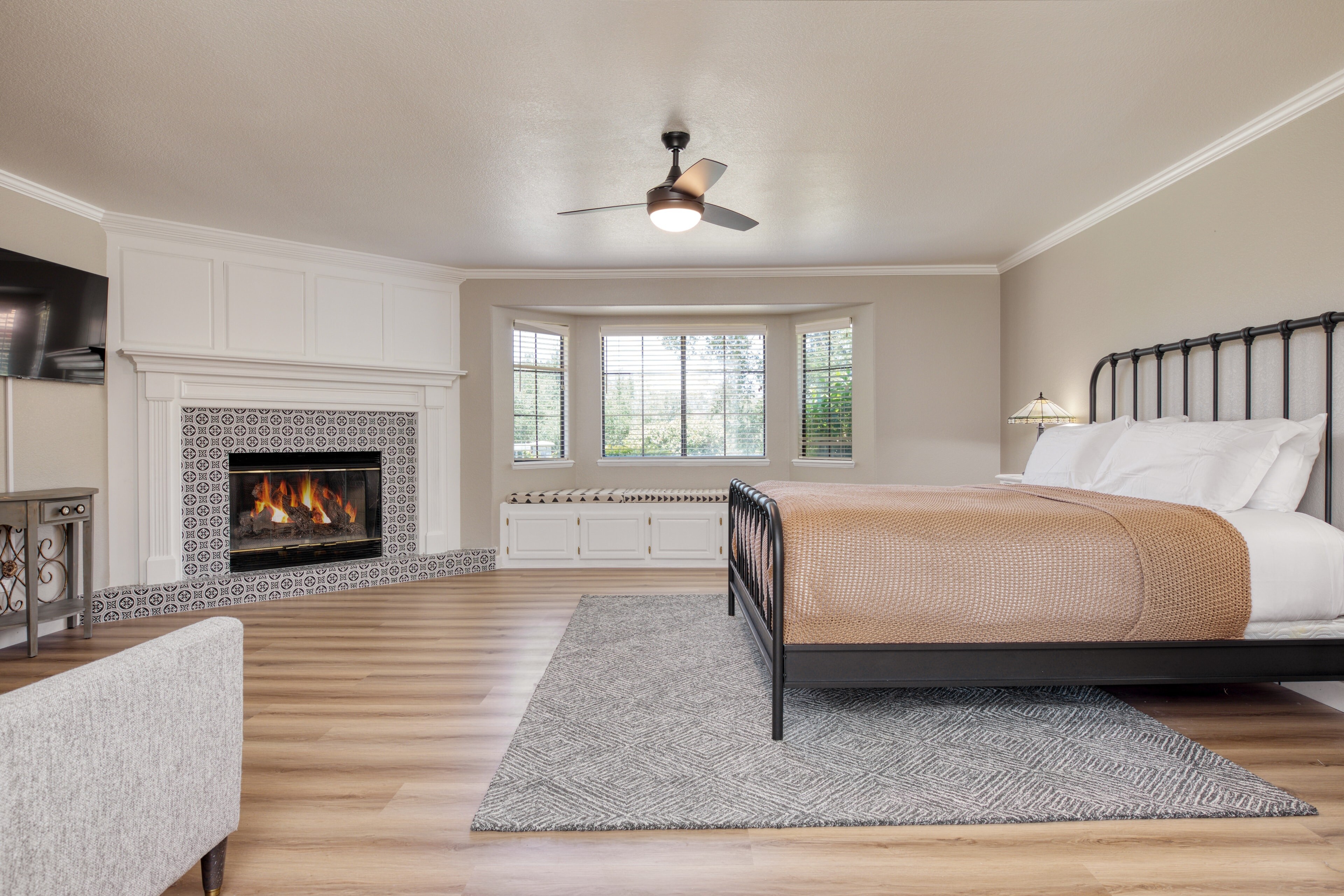 Primary bedroom features a king bed, fireplace, TV, bay window, and ensuite bathroom.