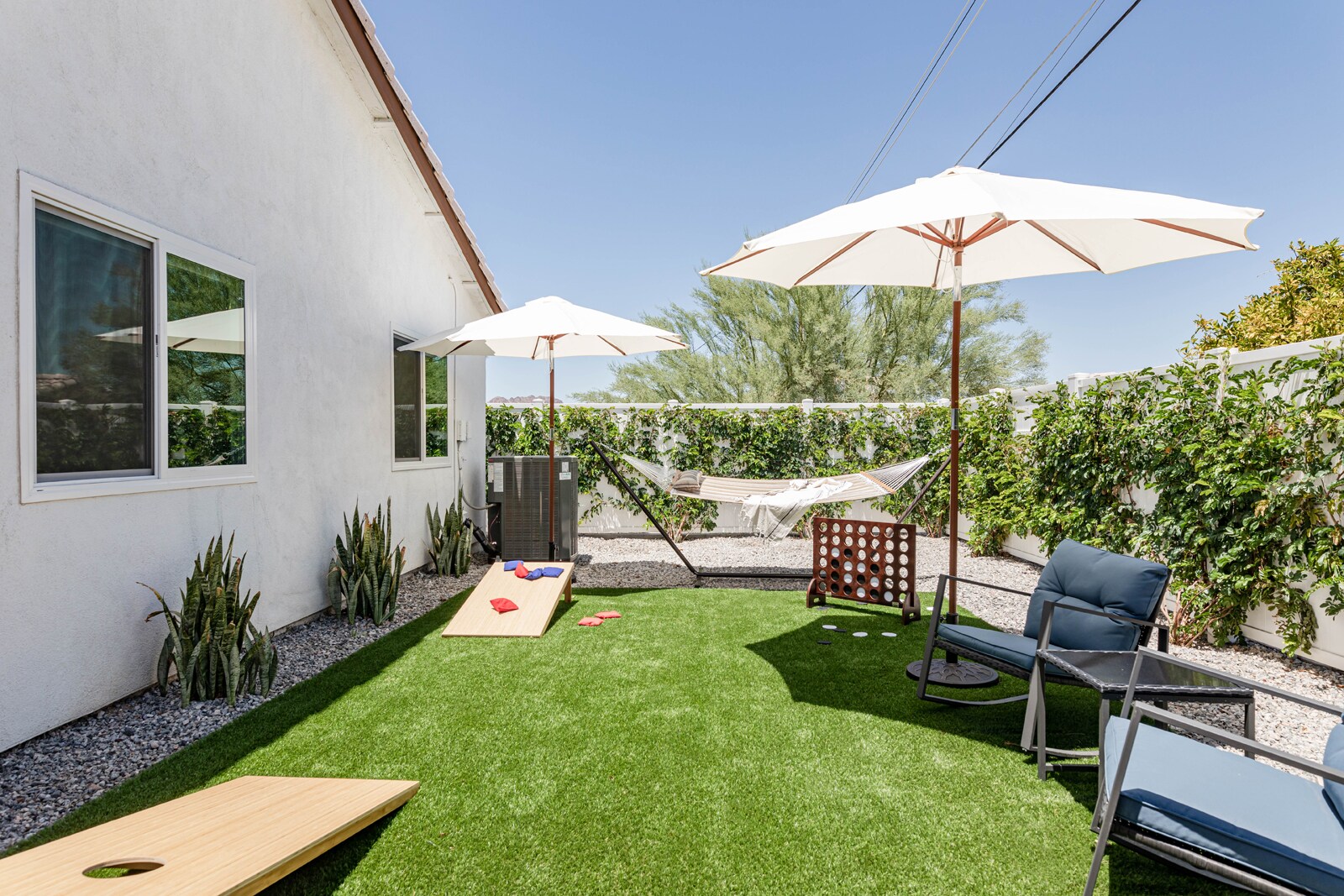 The back lawn offers shaded lounge space, games, and a hammock.