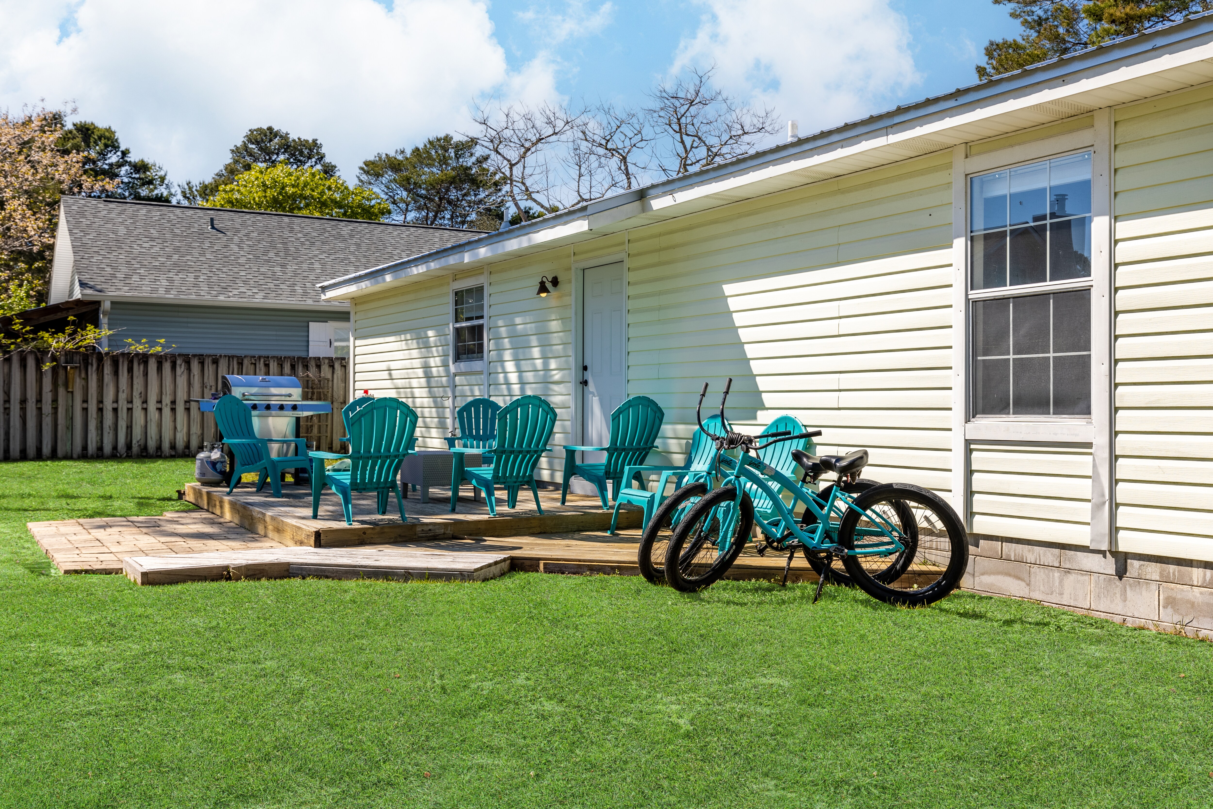 Large backyard comes with a patio lounge and two included bikes.