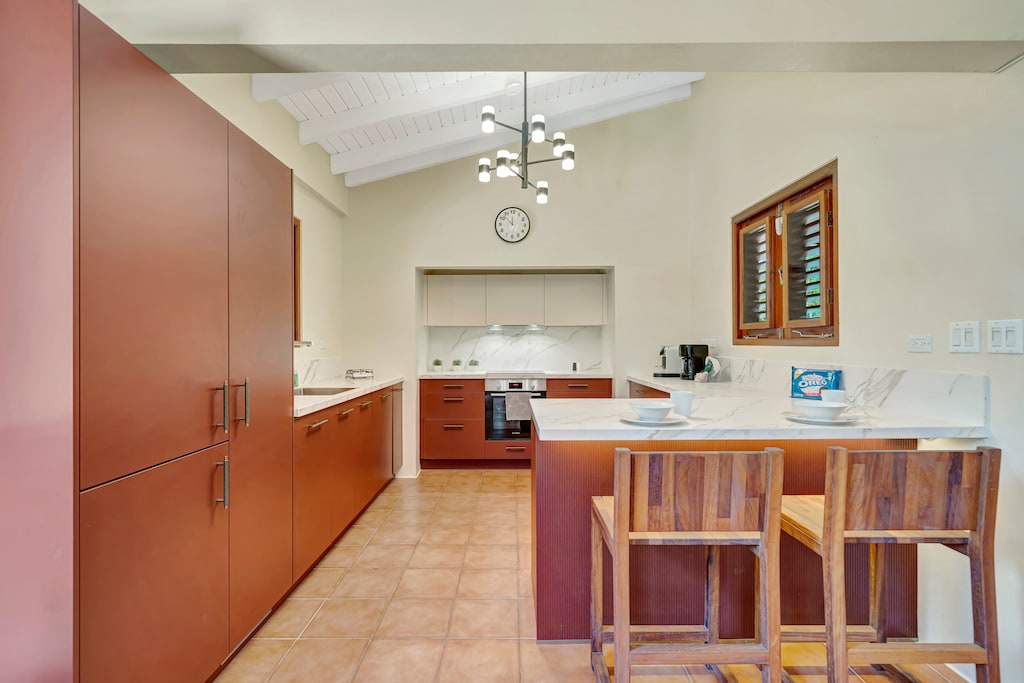 Kitchen offers stainless-steel appliances, spacious pristine white cabinetry and a deluxe range hood