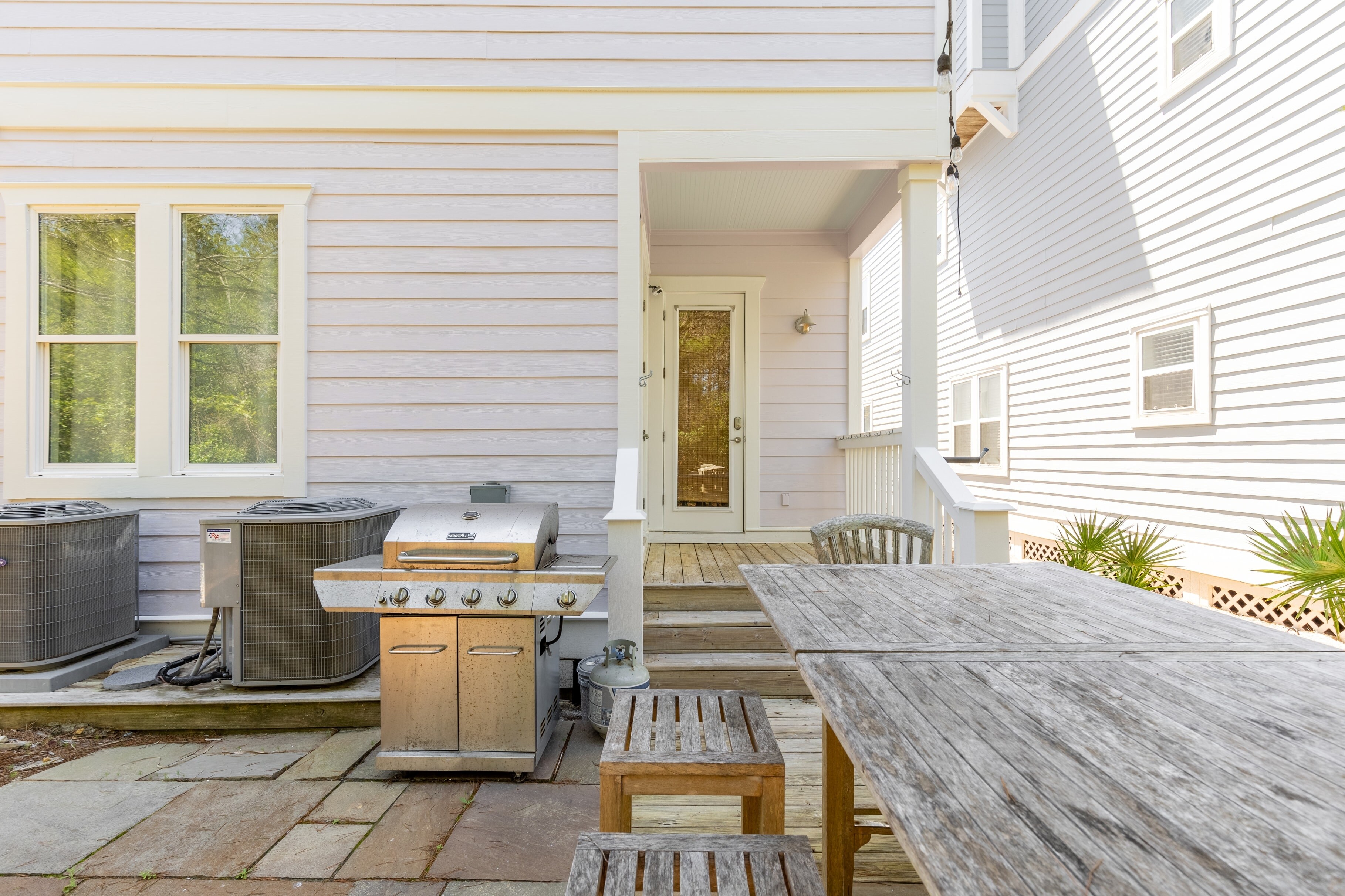 Lower patio with an outdoor dining table and BBQ grill.