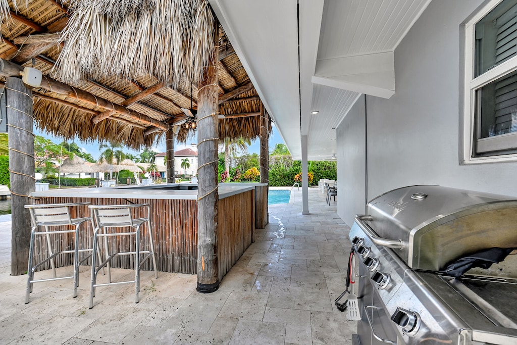 Tiki hut in yard with BBQ ready to grill