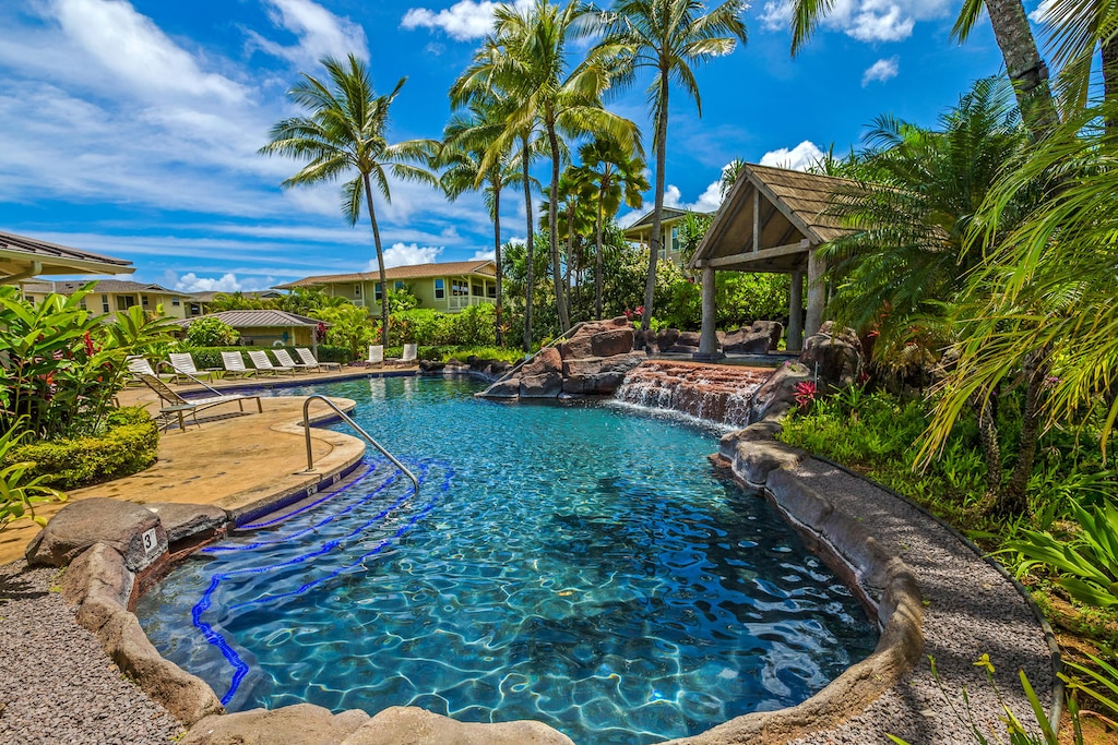 Resort-style community pool and hot tub surrounded by palms