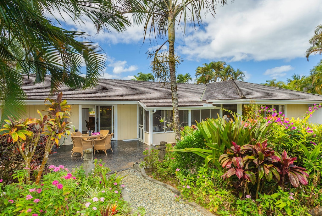 Mala Hale’s tropical garden and outdoor dining patio framed by lush island landscaping