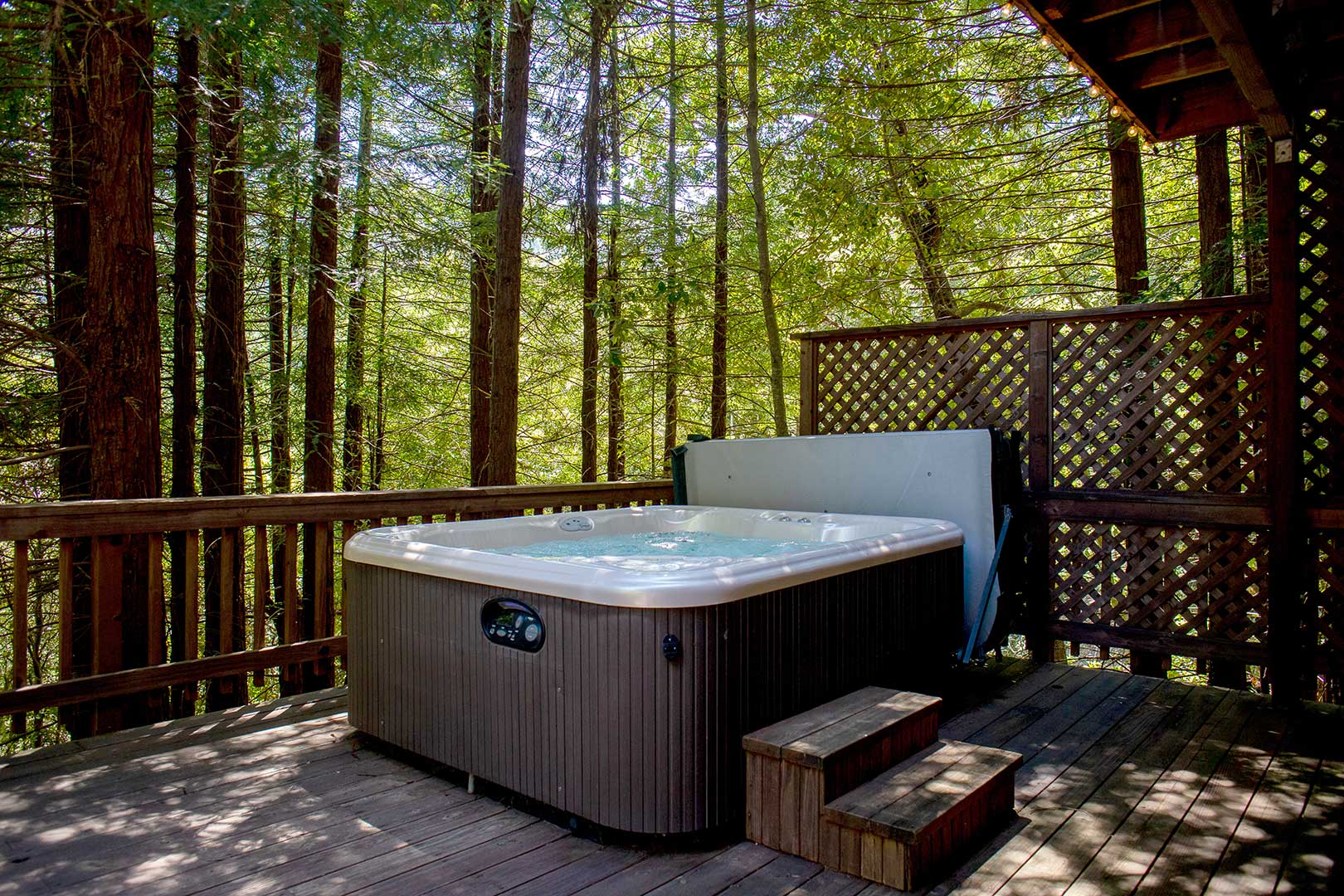 The 6 person hot tub on the lower deck looks up to redwoods!