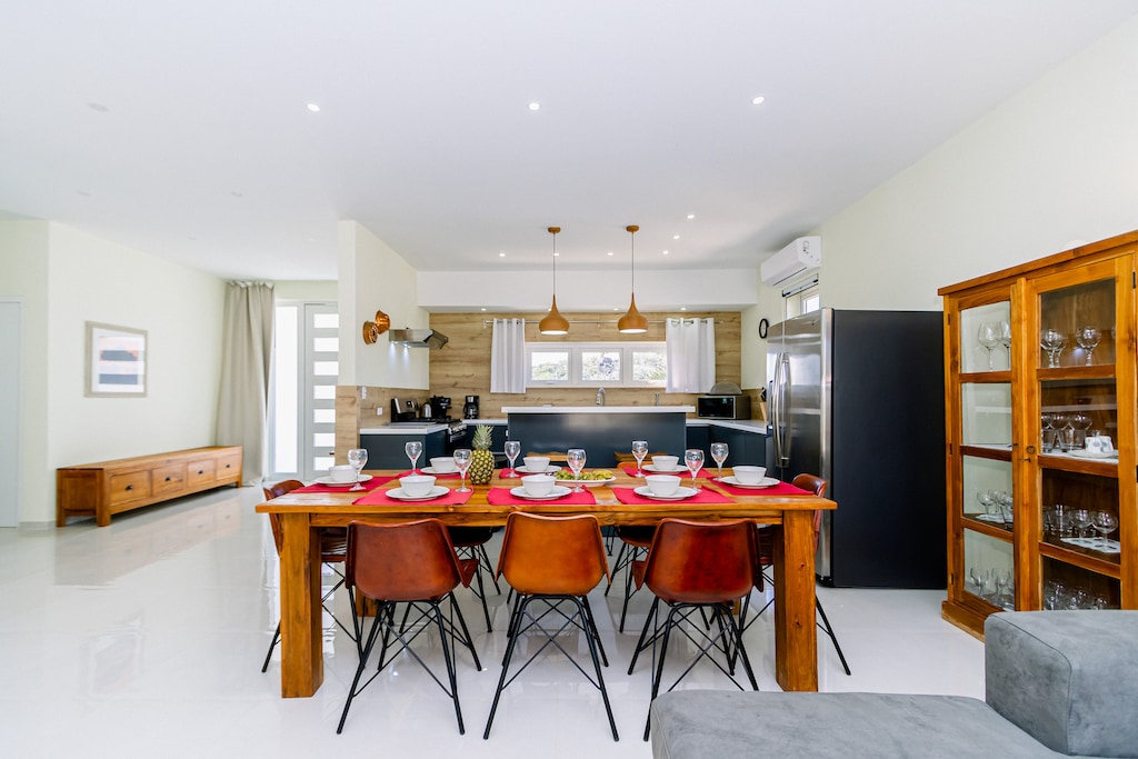 Palatine Dining Area of the 4BR Home in Noord Aruba - Sophisticated design with a blend of modern and classic elements - Artfully arranged table settings for a touch of elegance - Beautifully crafted dining table