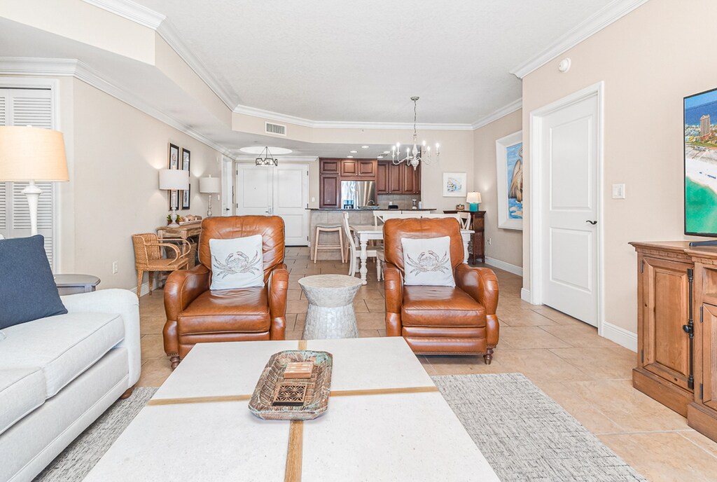 Sink into plush leather chairs in your elegant living space, where coastal artwork and warm lighting create the perfect atmosphere for relaxing evenings together.