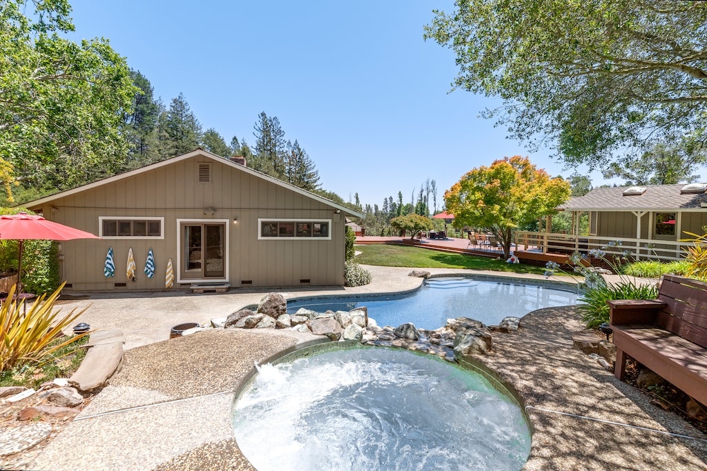 Like an oasis, the hot tub (avail. year round) overlooks the pool, lawn, and deck.