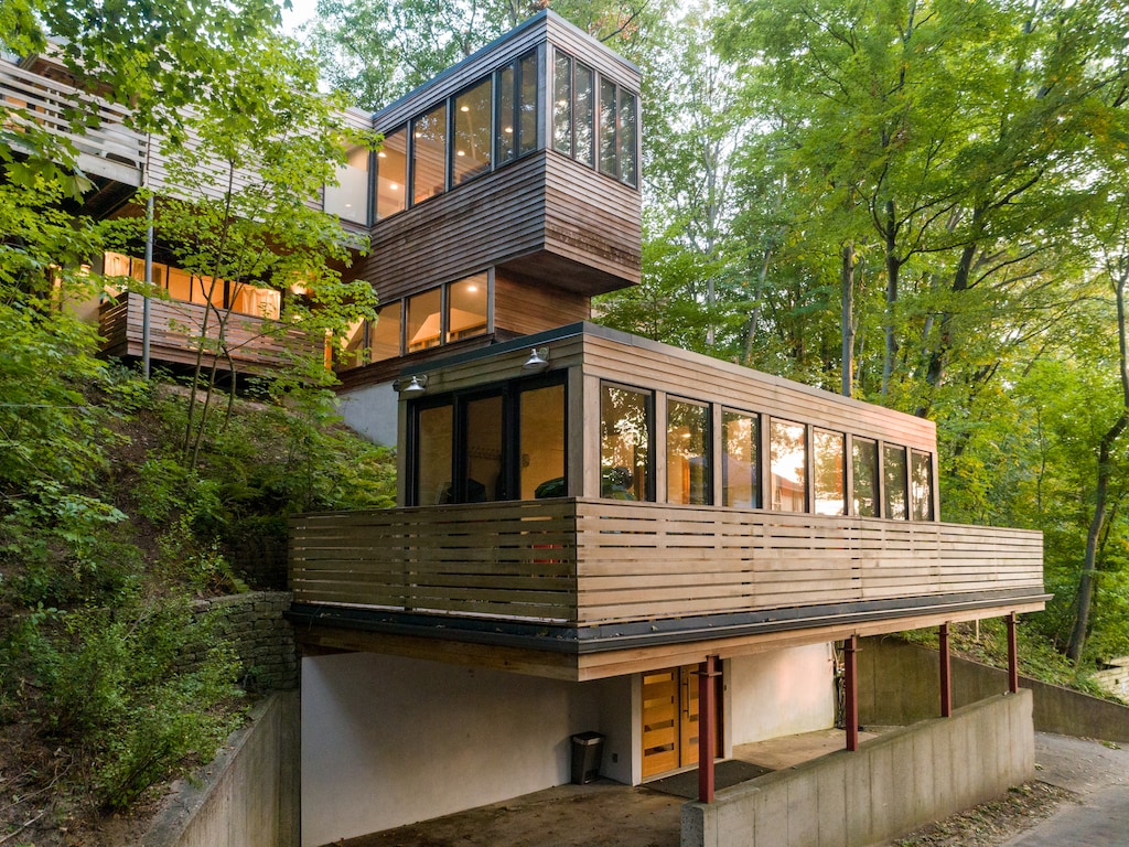 This stunning mid-century home is surrounded by lush woods while being just a short walk from private Lake Michigan beaches.