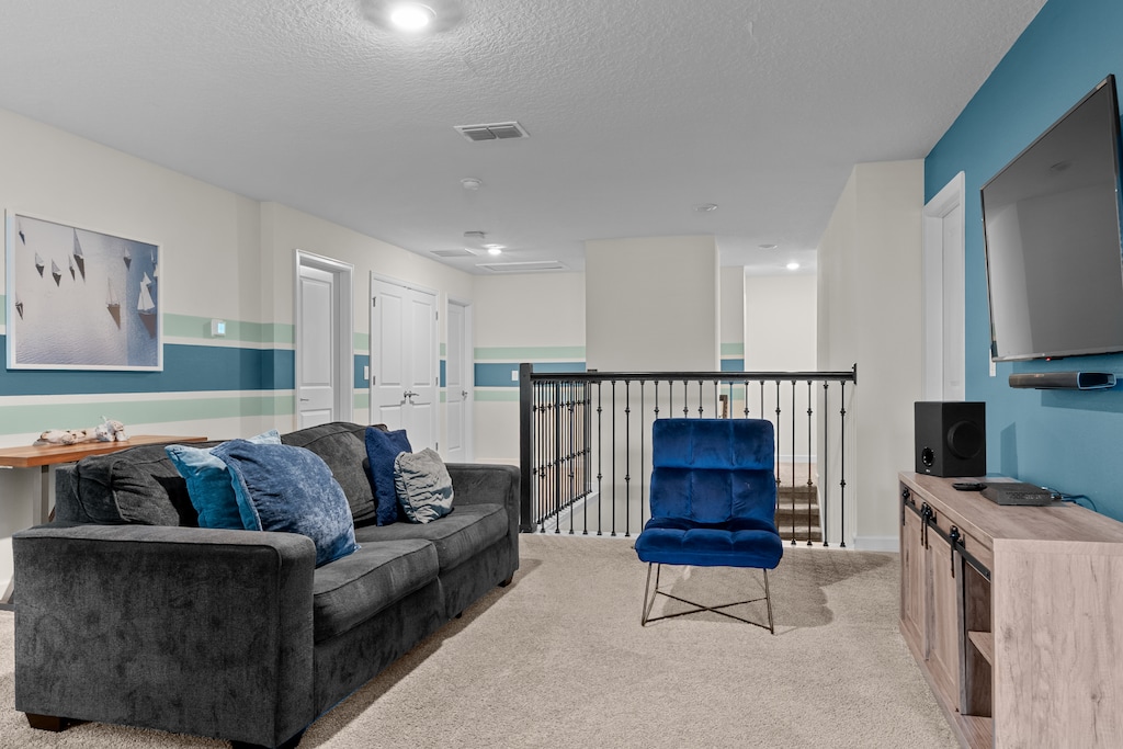 Settle into this stylish upstairs lounge where you can unwind on plush gray seating while enjoying entertainment on the mounted TV.