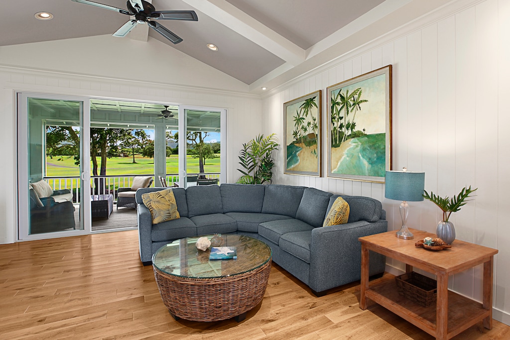 Gather with loved ones in the bright, open living room featuring high ceilings, wood floors, and comfortable seating.