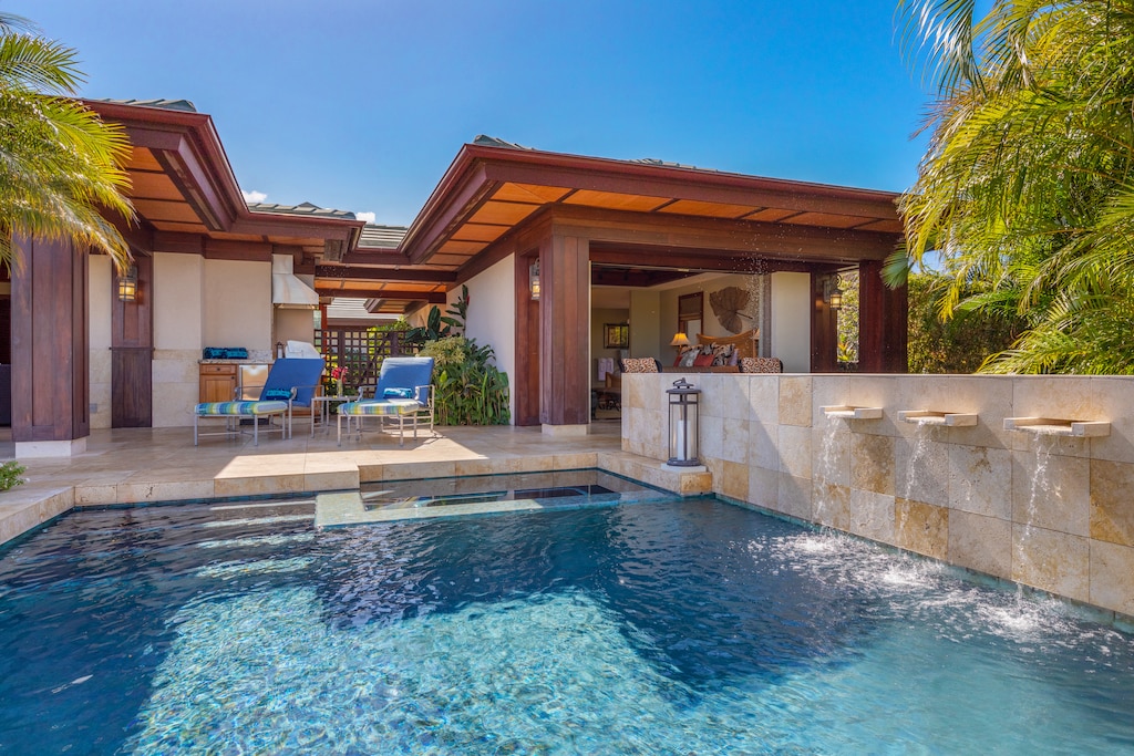Private pool with peaceful water features and shaded seating.
