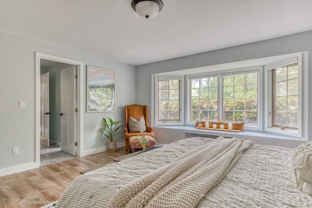 Airy bedroom with a cozy reading nook, bathed in natural light.