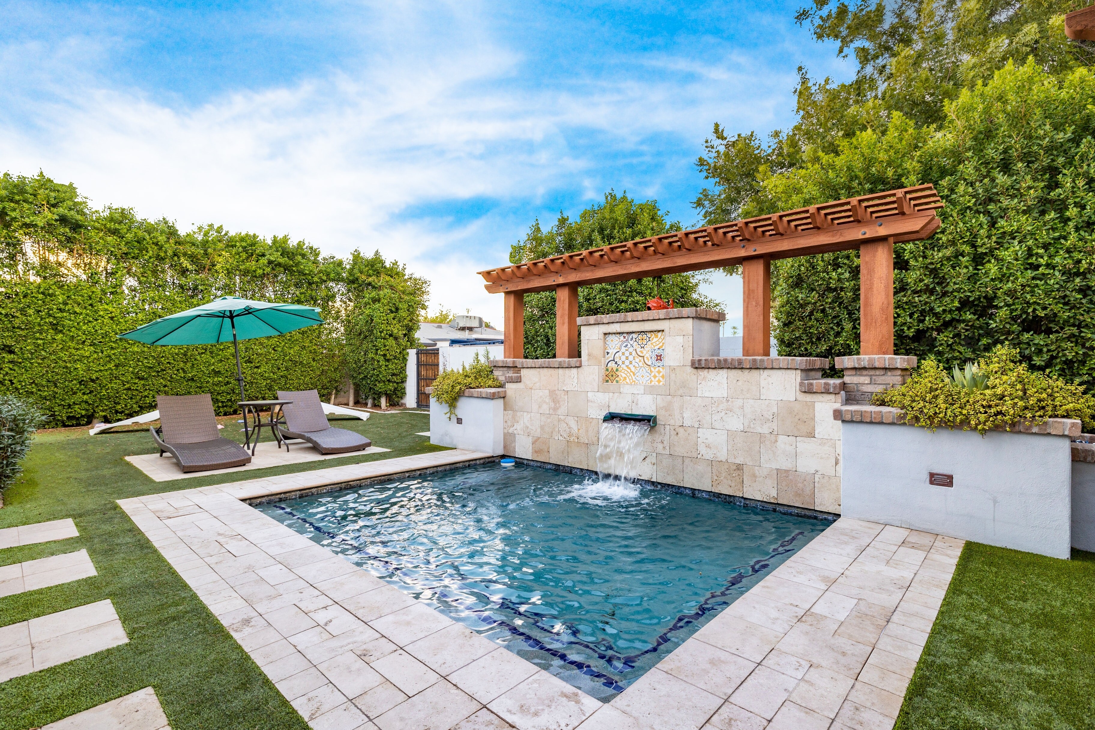 Backyard oasis with a pool and waterfall.