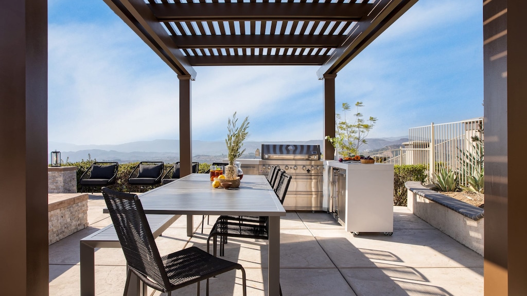 Outdoor dining table and grill near the pool.