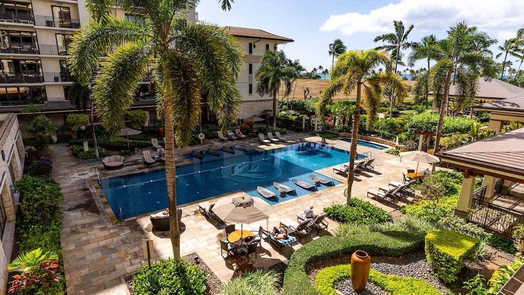 Resort-style pool surrounded by lush tropical landscaping and plenty of loungers for soaking up the Maui sun.