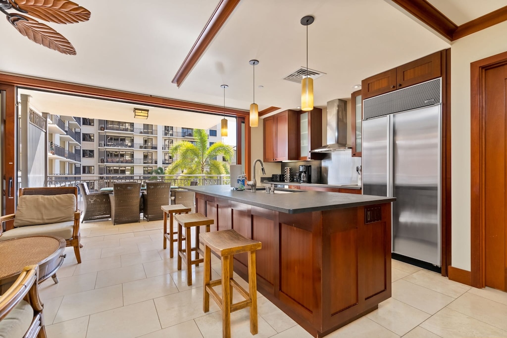 Kitchen with a large fridge and barstool seating at the island.