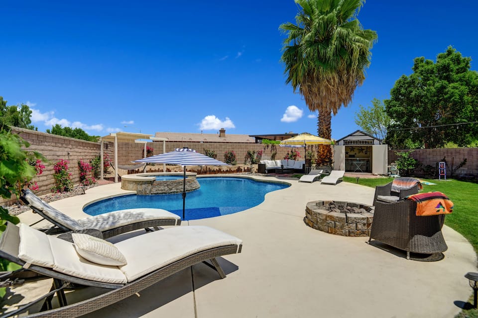 Spacious backyard features a pool, hot tub, fire pit, hammock, dining table, and multiple seating areas.