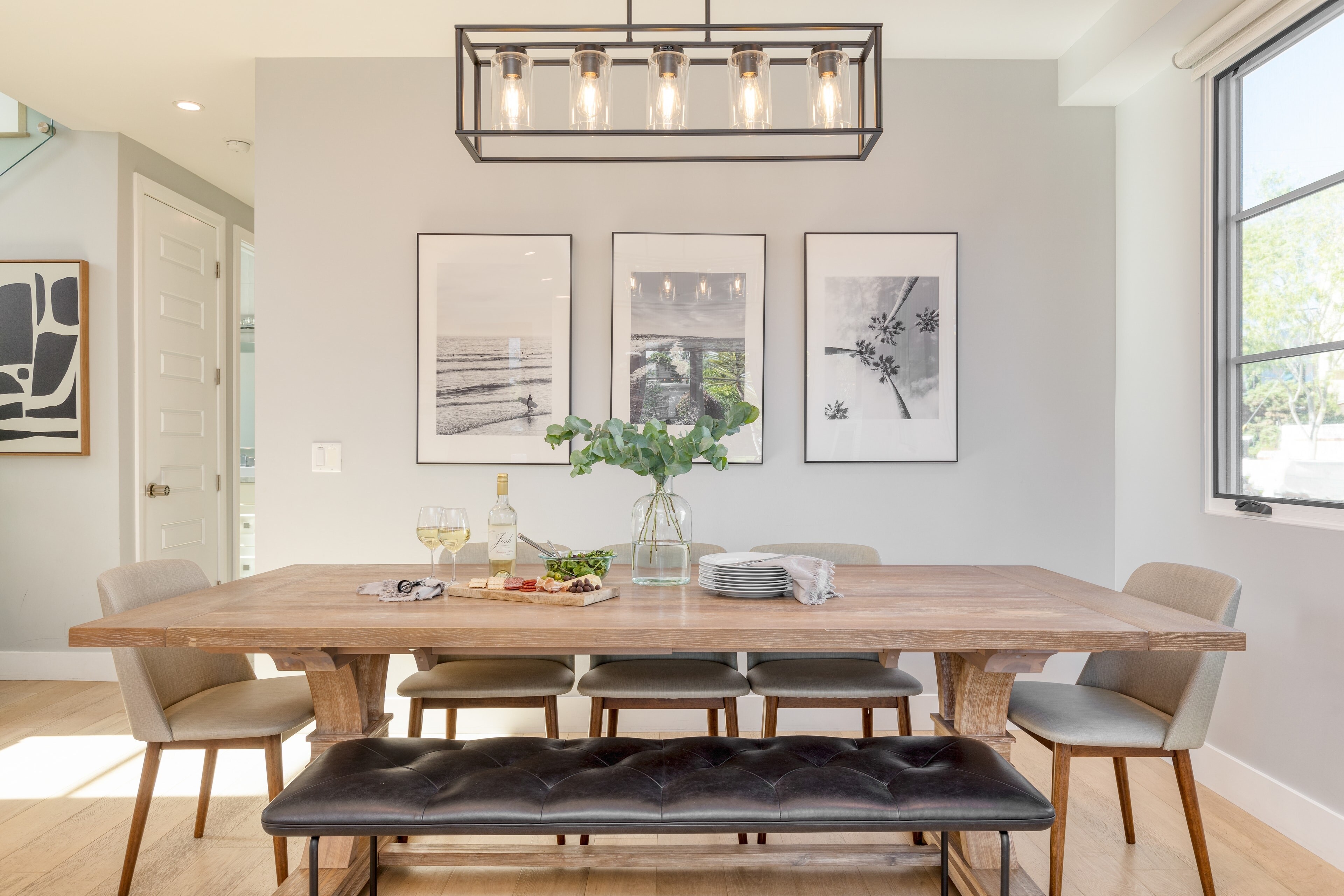 Chic dining area features a mix of traditional and bench seating.