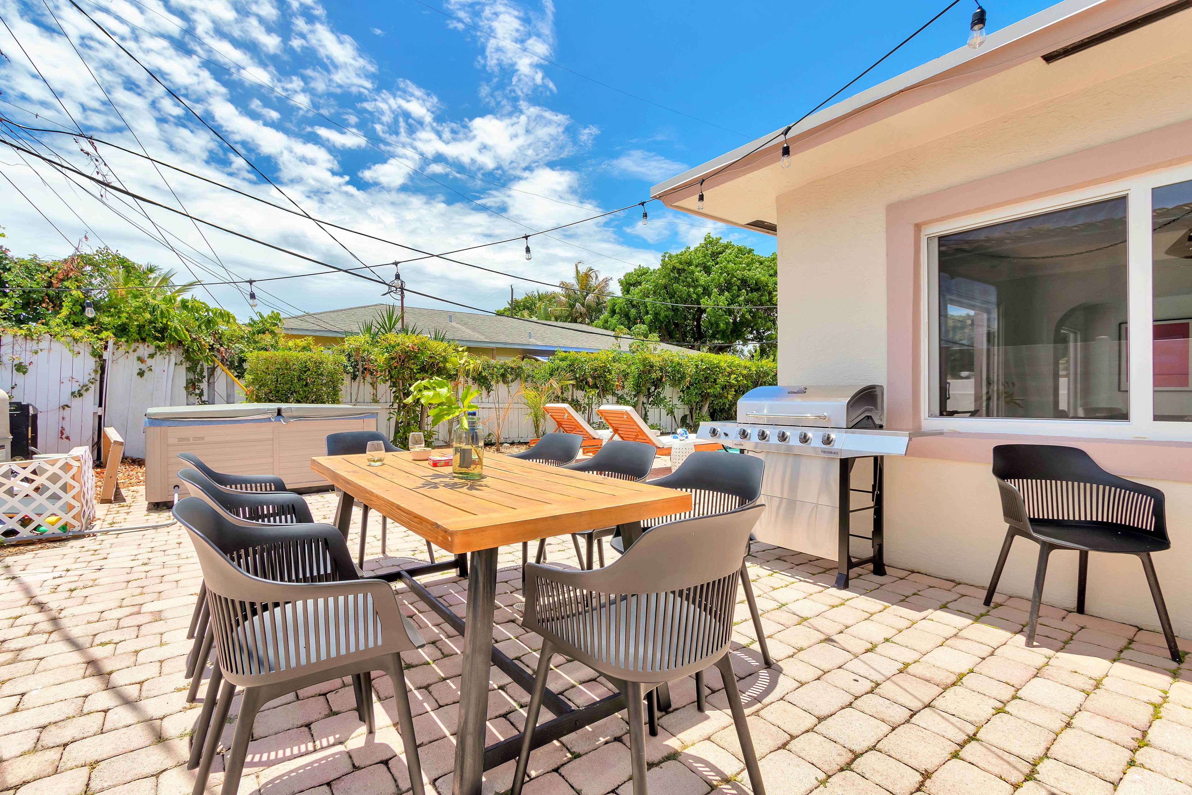 Outdoor dining table, grill and hot tub.