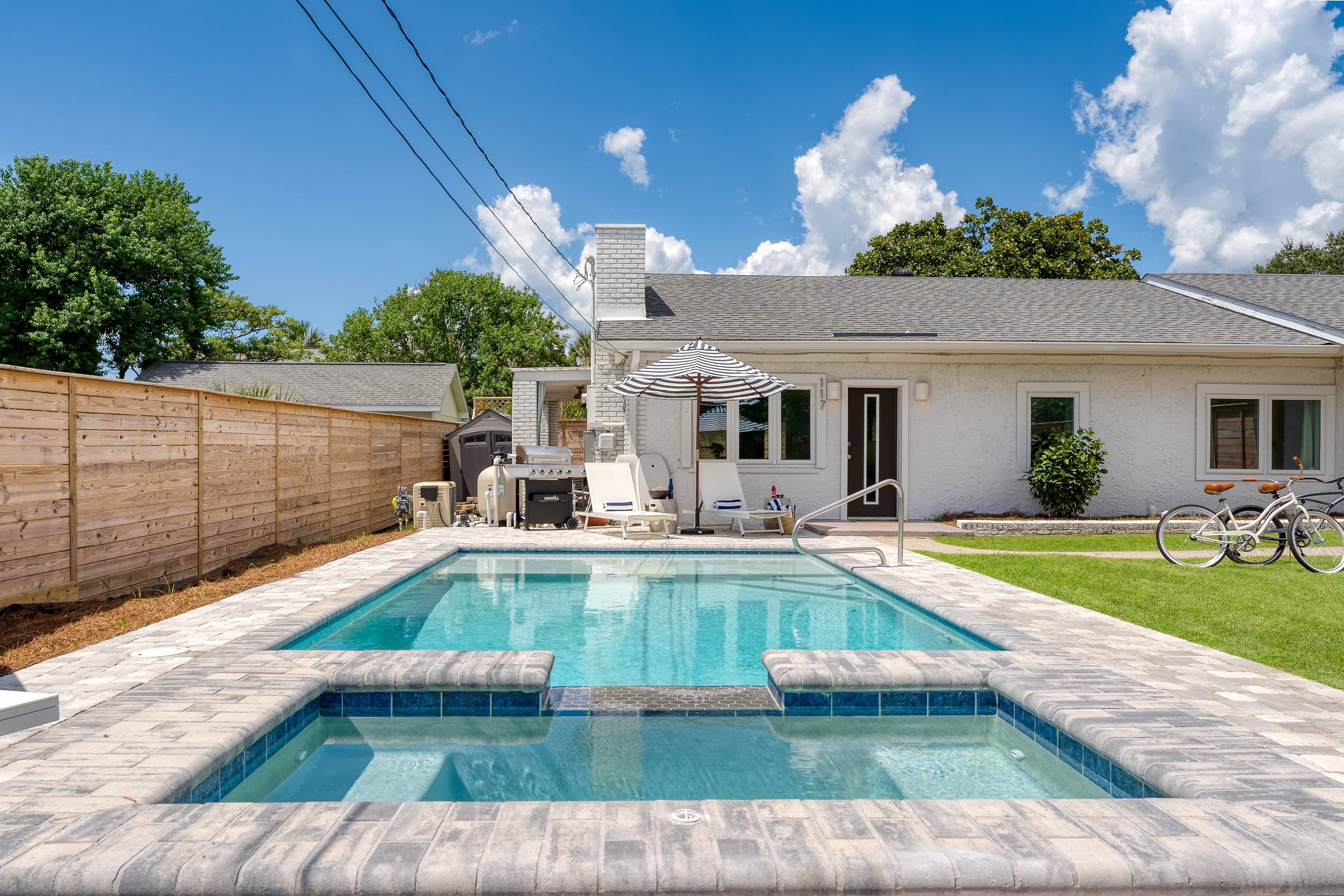 Your beachy backyard with a private pool, hot tub, patio, green space and two bicycles for your use.