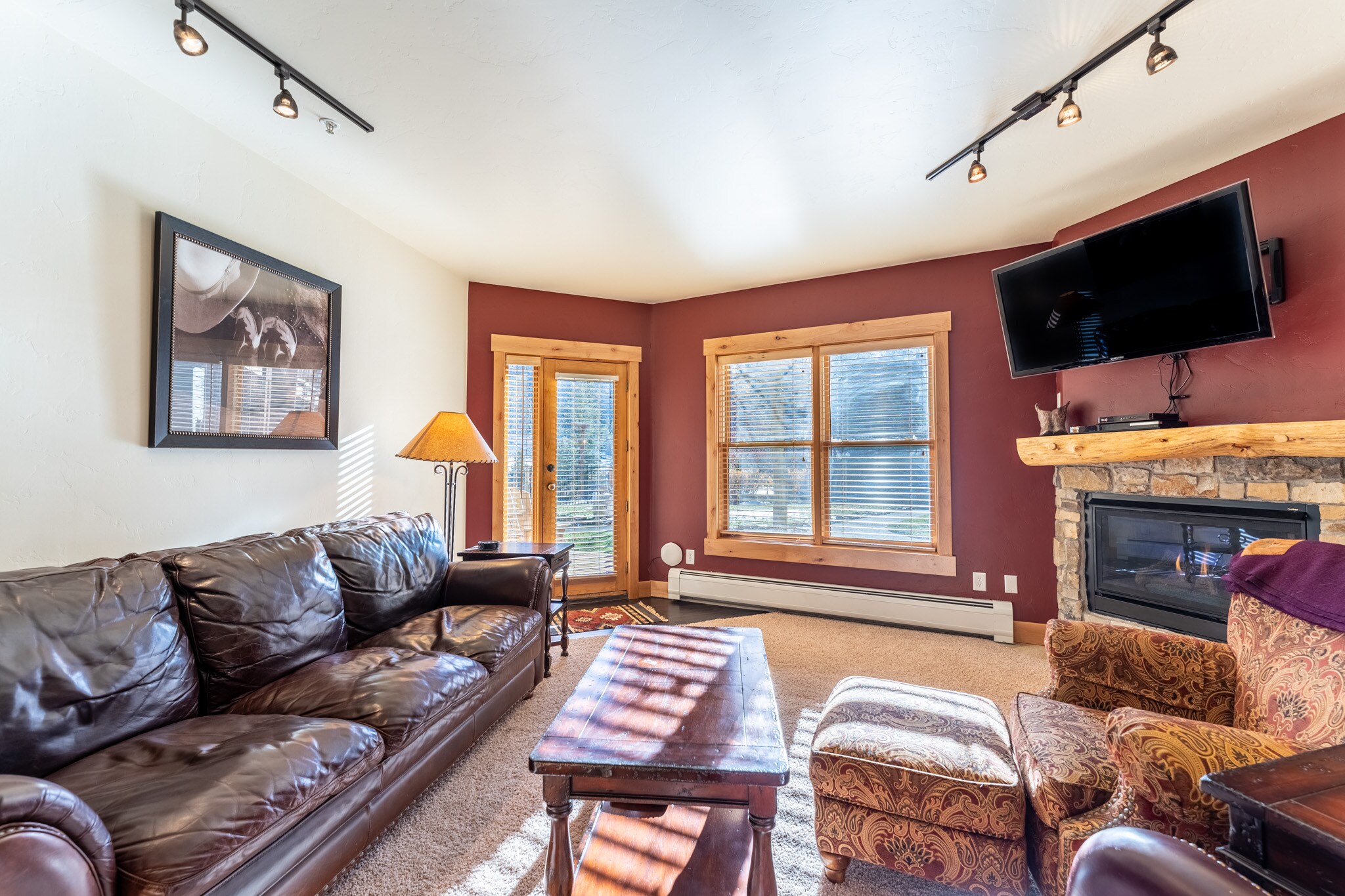 Living area offering cozy furnishings, a gas fireplace, and mounted Smart TV&gt; 