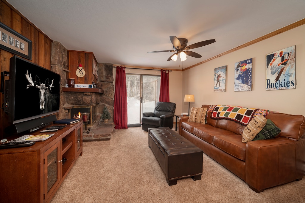 Your cozy living room features leather sofas, stone fireplace, and mountain-themed decor for perfect après-ski relaxation.