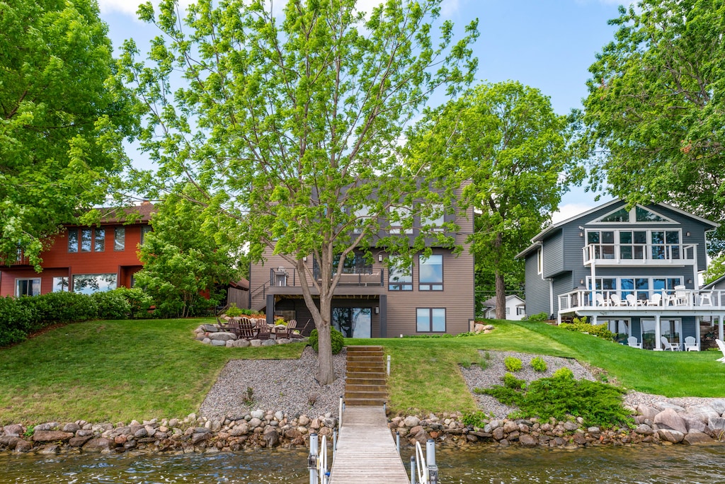 Waterfront property nestled among mature trees with private dock and lake access in a tranquil residential setting.