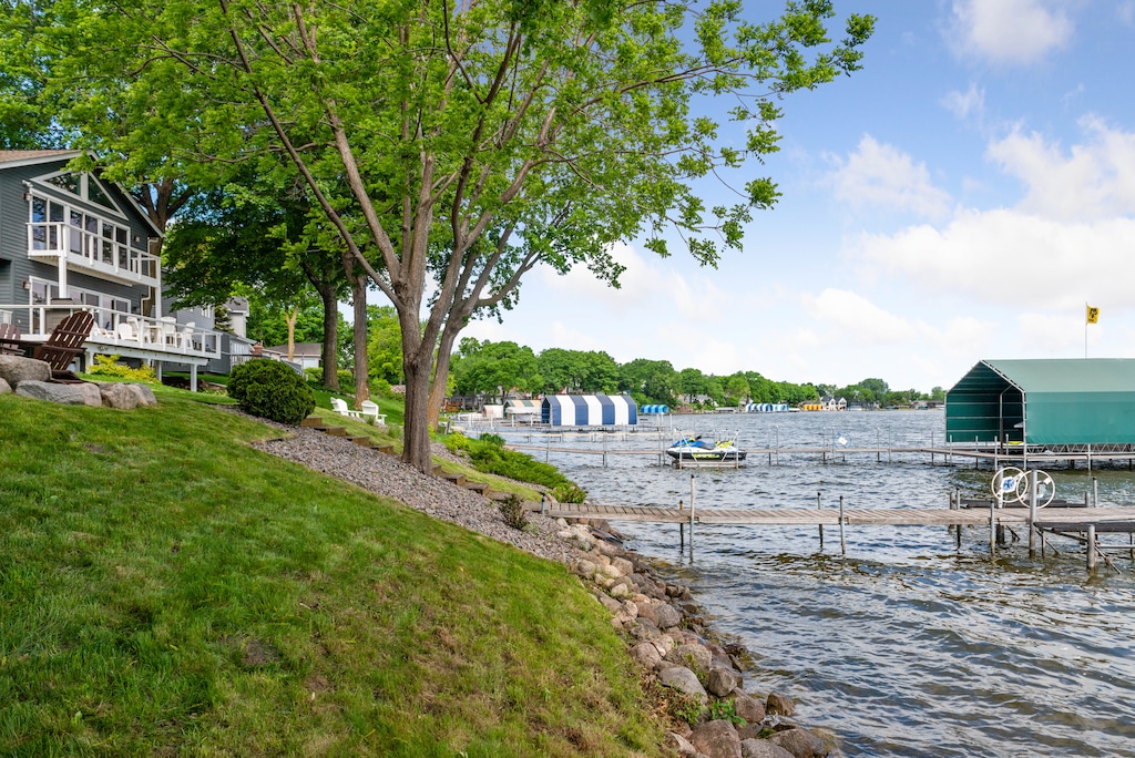 Lakefront property with private docks and boat slips surrounded by mature trees and scenic waterfront neighborhood.