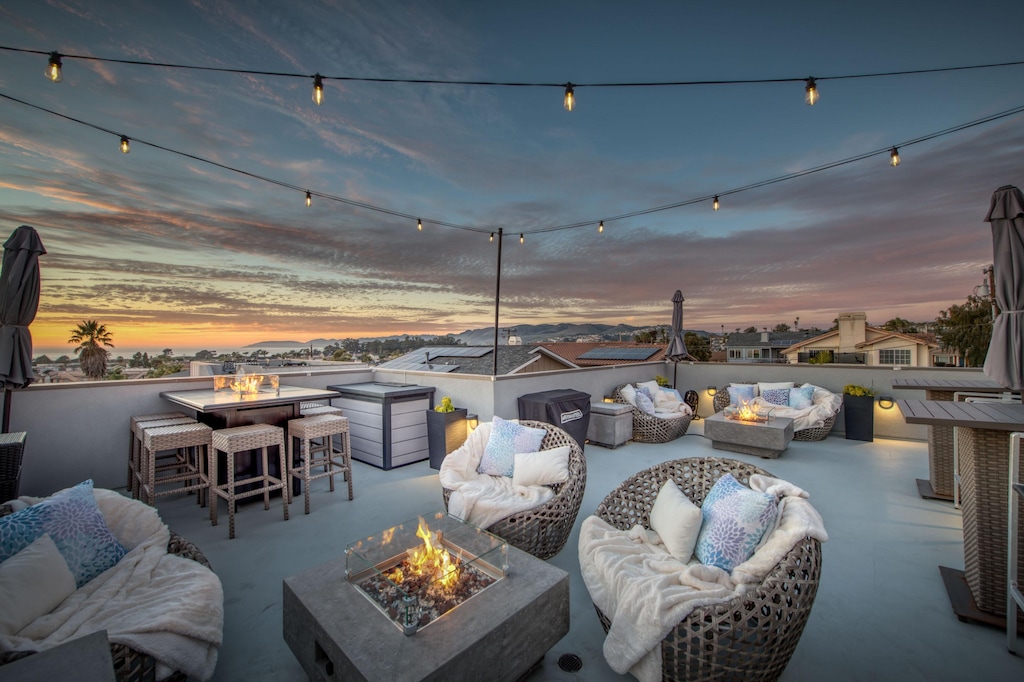 Multiple fire fixtures illuminate the roof deck create an elegant ambiance. Outdoor furniture extend living space.