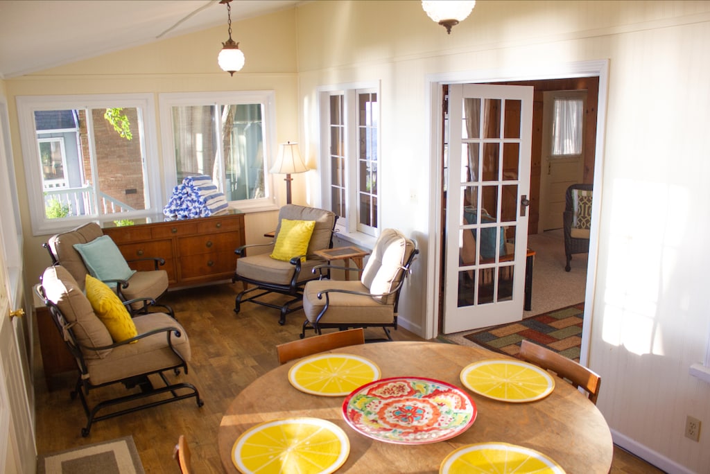 Sun room with comfy sitting area and additional dining table.