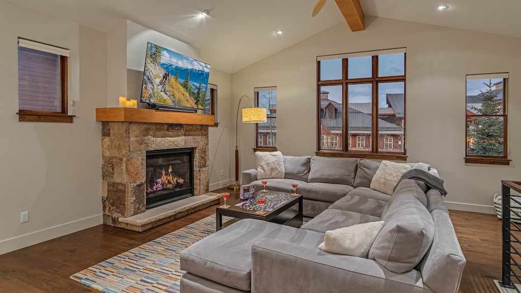 Main level great room with gas fireplace, TV, and deck access